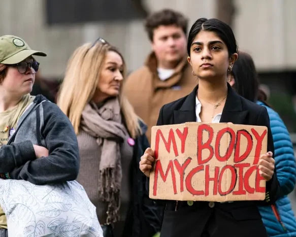 Woman holding sign at rally saying